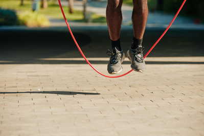 male feet jumping rope outdoors