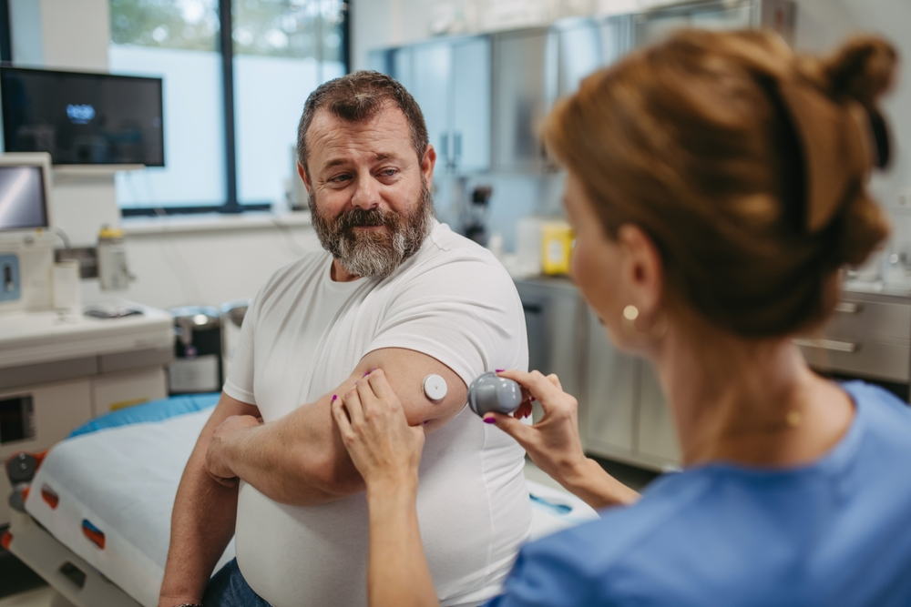 doctoring applying glucose monitor to diabetic patient's arm