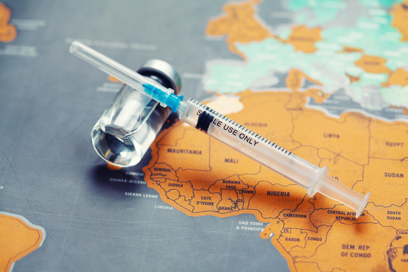 vaccine vial and syringe on world map
