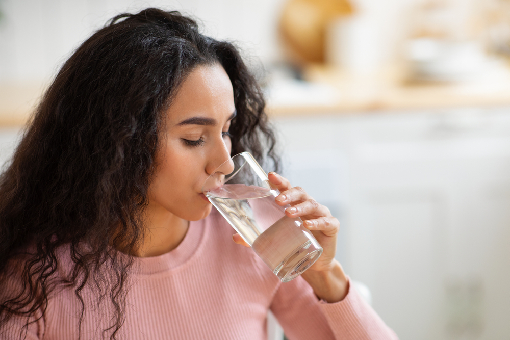 young woman drinking water from a glass