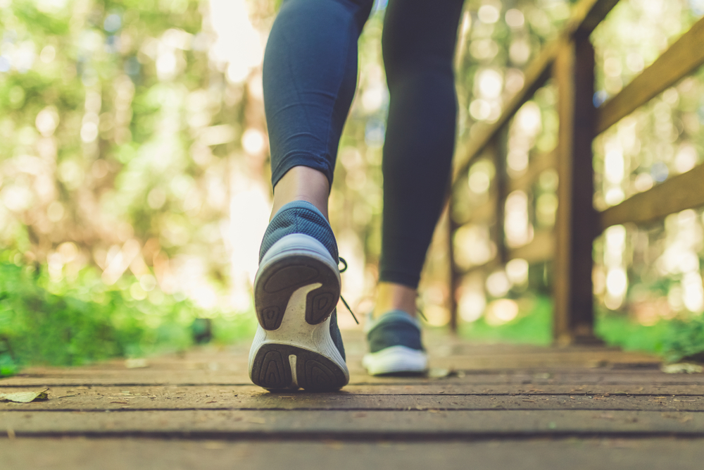 close up of sneaker-clad feet walking across a bridge