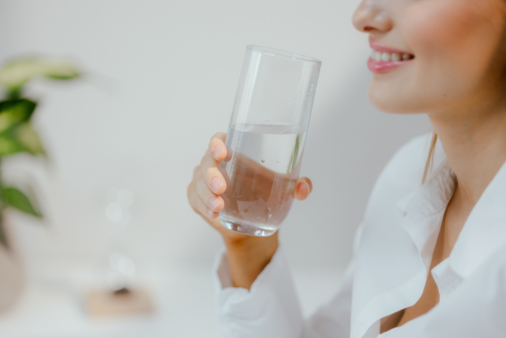 smiling woman drinking water from glass