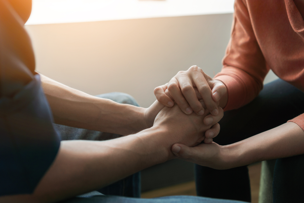 two people holding hands while talking