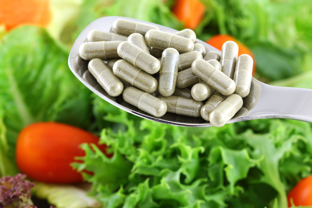 spoonful of fiber capsules over vegetables